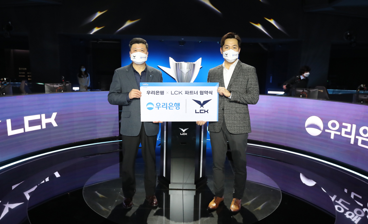 우리은행은 지난 19일 서울 종로구 롤파크에서 ‘리그 오브 레전드 챔피언스 코리아(LCK)’와 파트너 계약을 체결했다. 권광석(왼쪽) 우리은행장과 오상헌(오른쪽) LCK 대표가 기념촬영을 하고 있다.