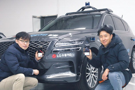 LG유플러스 자율주행기술팀 권정호 책임(좌)과 하남수 책임(우)이 5G 자율주차 앱을 실행하며 포즈를 취하고 있다. [LG유플러스 제공]