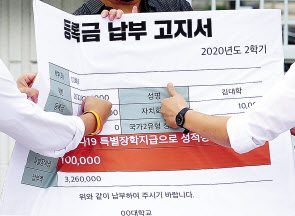 서울 종로구 정부서울청사 앞에서 열린 ‘코로나시대 대학생 권리찾기 운동 선포 기자회’견에서 청년진보당 관계자들이 지난해 10월 등록금 100만원 상한제 추진, 등록금 반환에 대한 교육부의 관리 감독과 기준 마련을 촉구하며 등록금 납부 고지서를 주먹으로 치는 퍼포먼스를 하고 있다. [연합]