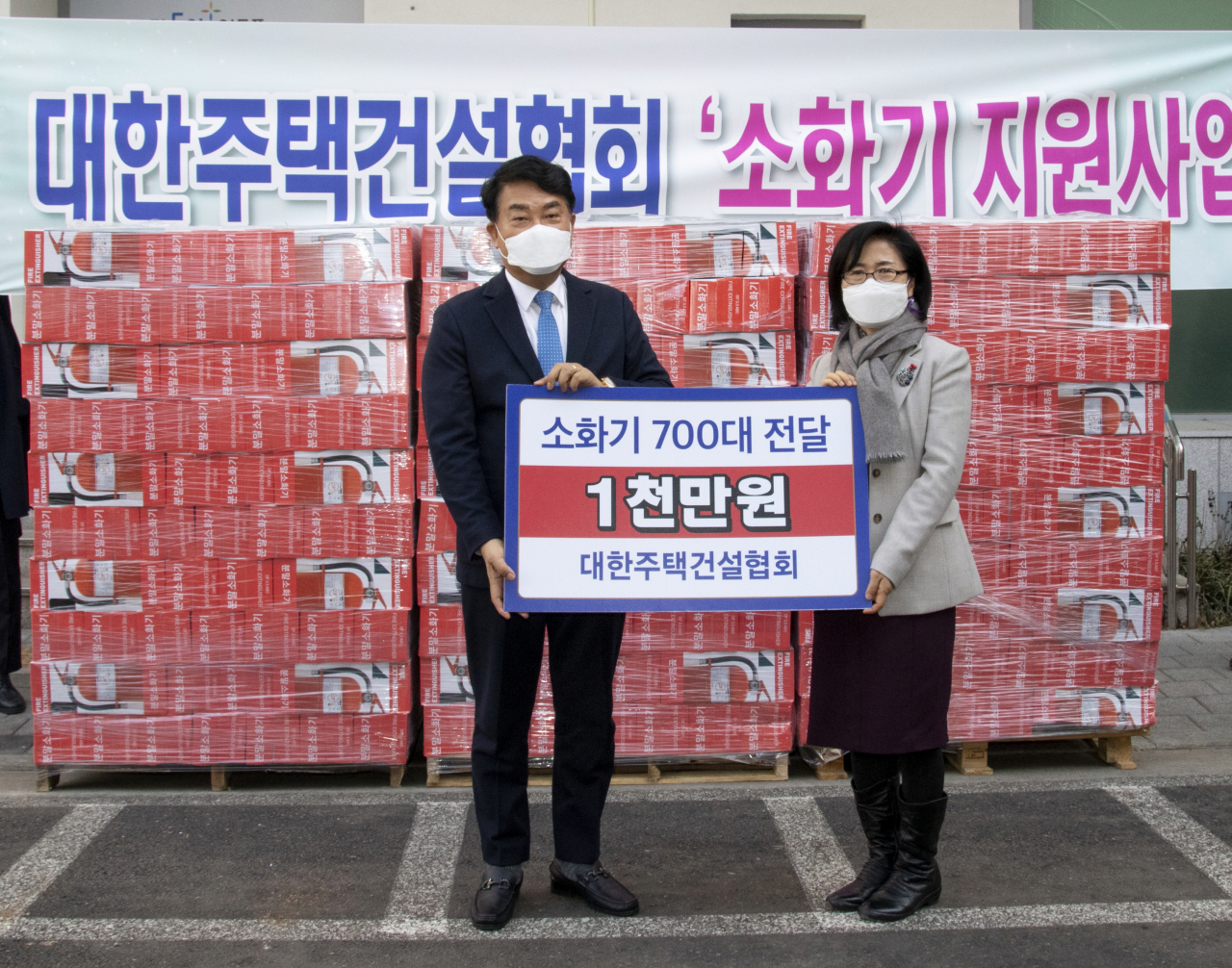 박재홍 대한주택건설협회 회장(왼쪽)이 20일 서울 영등포구청 별관 앞에서 '소화기 700대 기증서'를 전달하고 있다.