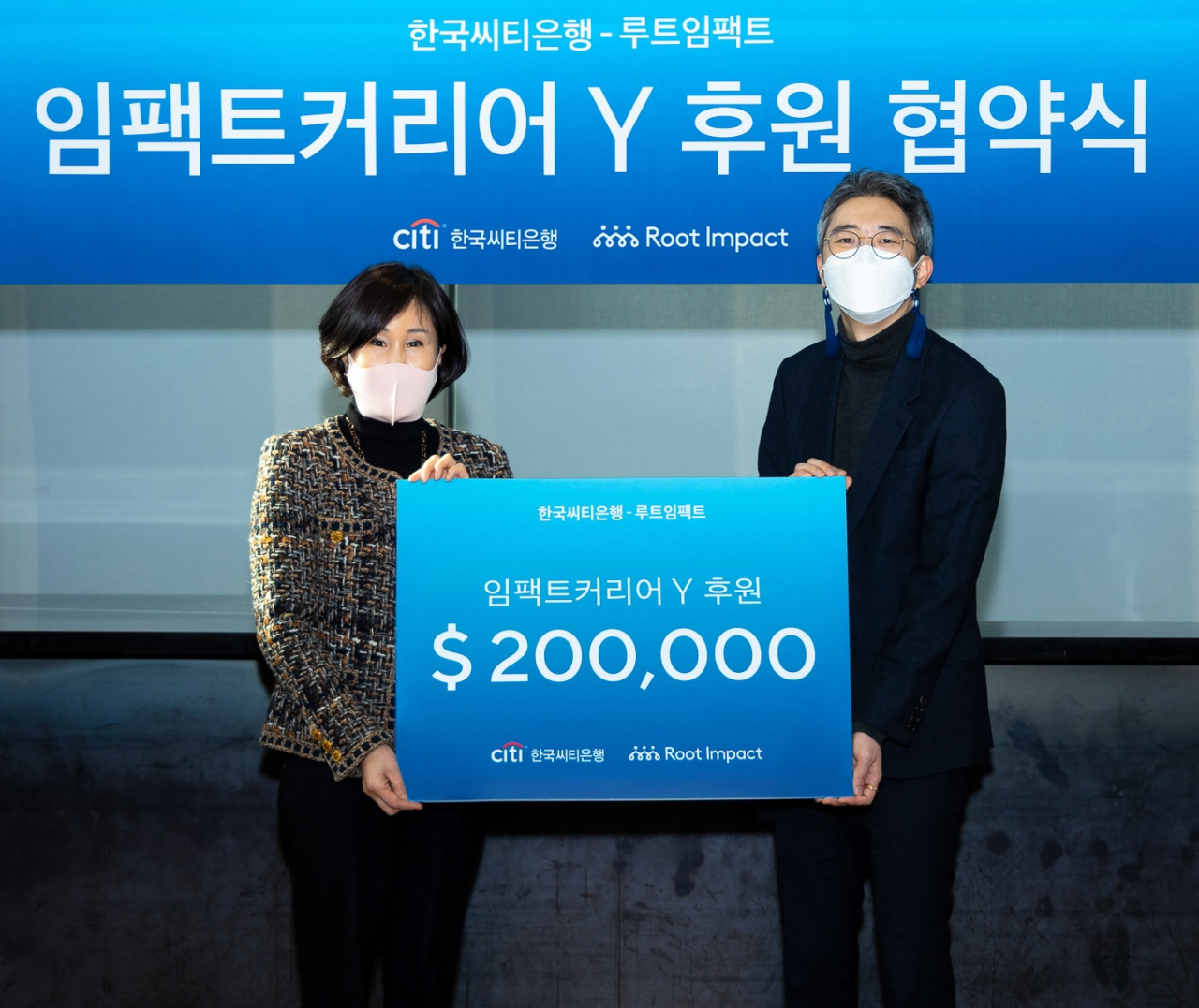 한국씨티은행은 20일 오후 서울 성동구 성수동 소재 헤이그라운드 성수 시작점에서 루트임팩트와 함께 ‘임팩트커리어Y 프로그램’ 후원 협약식을 가졌다. 이날 협약식에서 유명순 한국씨티은행장(좌측)이 허재형 루트임팩트 대표(우측)에게 후원금을 전달하고 있다. [한국씨티은행 제공]