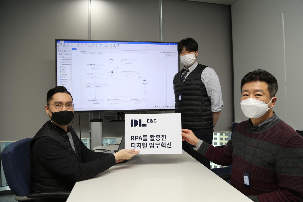 DL이앤씨 직원들이 RPA 업무 자동화 도입을 설명하는 피켓카드를 들고 있다. [DL이앤씨 제공]