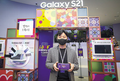 22일 SK텔레콤 갤럭시S21 개통 행사에서 1호 개통 고객 배인우씨(서울)가 기념 촬영을 진행하고 있다.
[SK텔레콤 제공]
LG유플러스 갤럭시S21 사전개통 1호고객이 기념사진을 찍고 있다.
[LG유플러스 제공]
KT가 지난 21일 저녁 진행한 갤럭시S21 사전개통 행사에서 방송인 박권(왼쪽)과 먹방 BJ 쯔양이 갤럭시S21을 소개하고 있다.
[KT 제공]