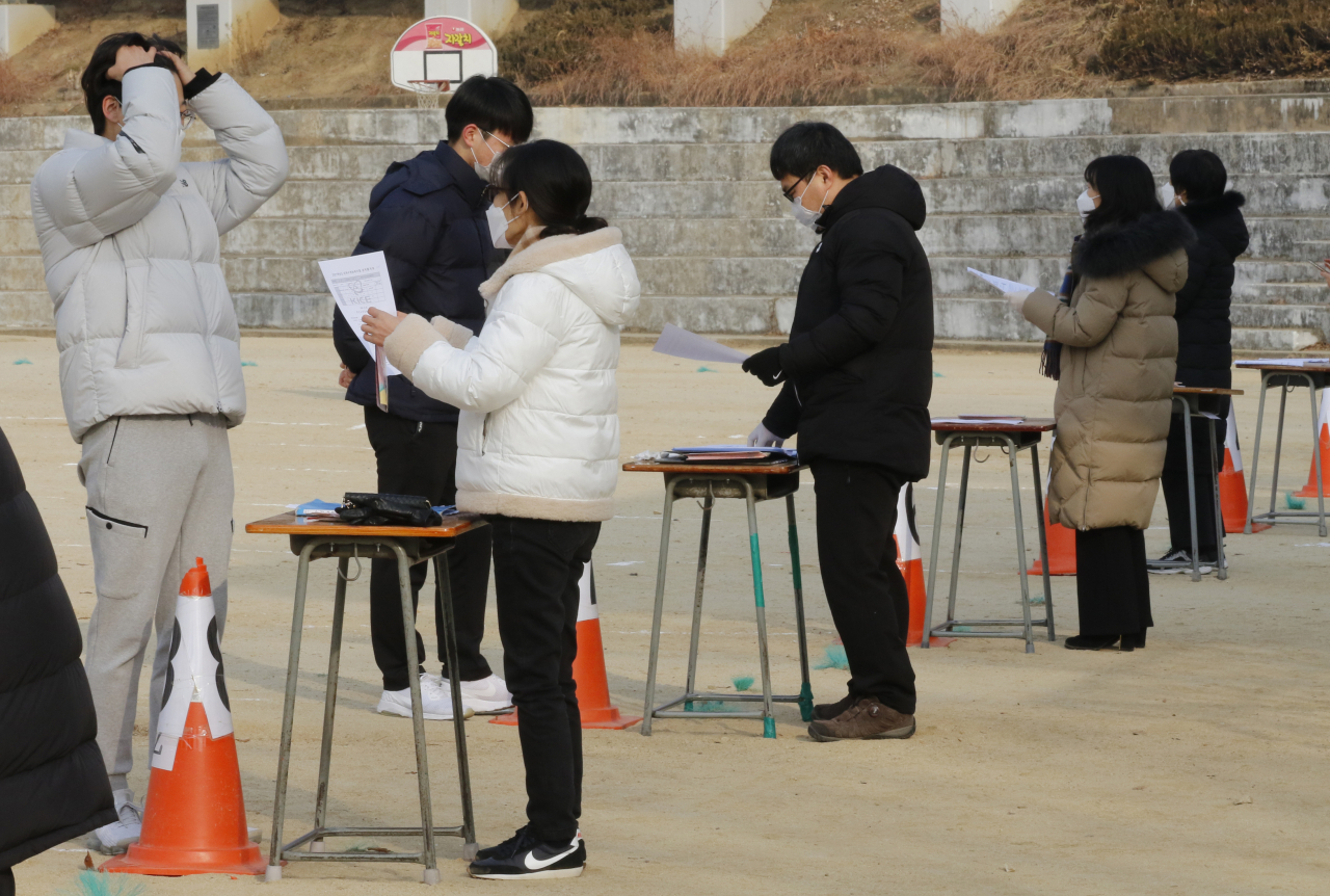 지난해 12월 대구 수성구 경북고등학교 운동장에서 수험생들이 수능 성적표를 받고 있는 모습. [연합]