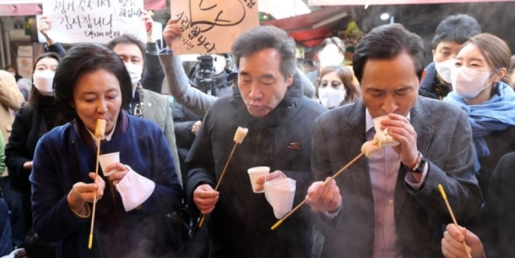 이낙연 더불어민주당 대표가 23일 서울 중구 남대문시장에서 서울시장 보궐선거 경선에 나서는 우상호 의원(오른쪽), 박영선 전 중소벤처기업부 장관(왼쪽)과 어묵을 먹고 있다.[연합]