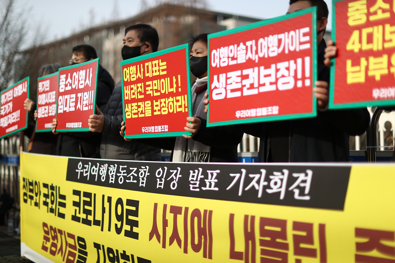 25일 서울 국회 앞에서 열린 ‘여행업계 생존권 보장을 위한 운영자금 지원 요청, 우리여행협동조합 입장 발표 기자회견’에서 참석자들이 관련 구호를 외치고 있다. [연합]