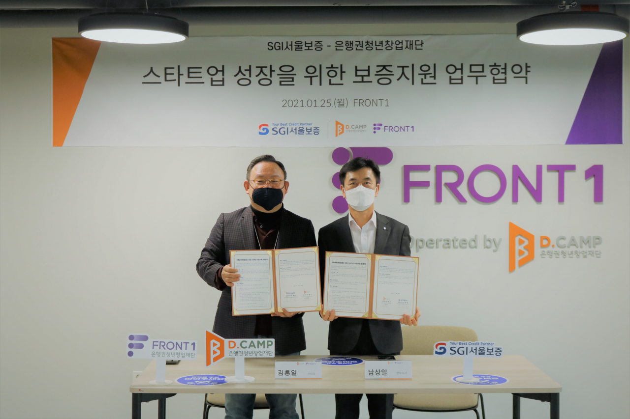 남상일 SGI서울보증 전무이사(오른쪽)와 김홍일 디캠프 센터장이 25일 서울 마포구 프런트1에서 ‘패밀리사 보증지원 업무협약’을 체결하고 있다. [SGI서울보증 제공]