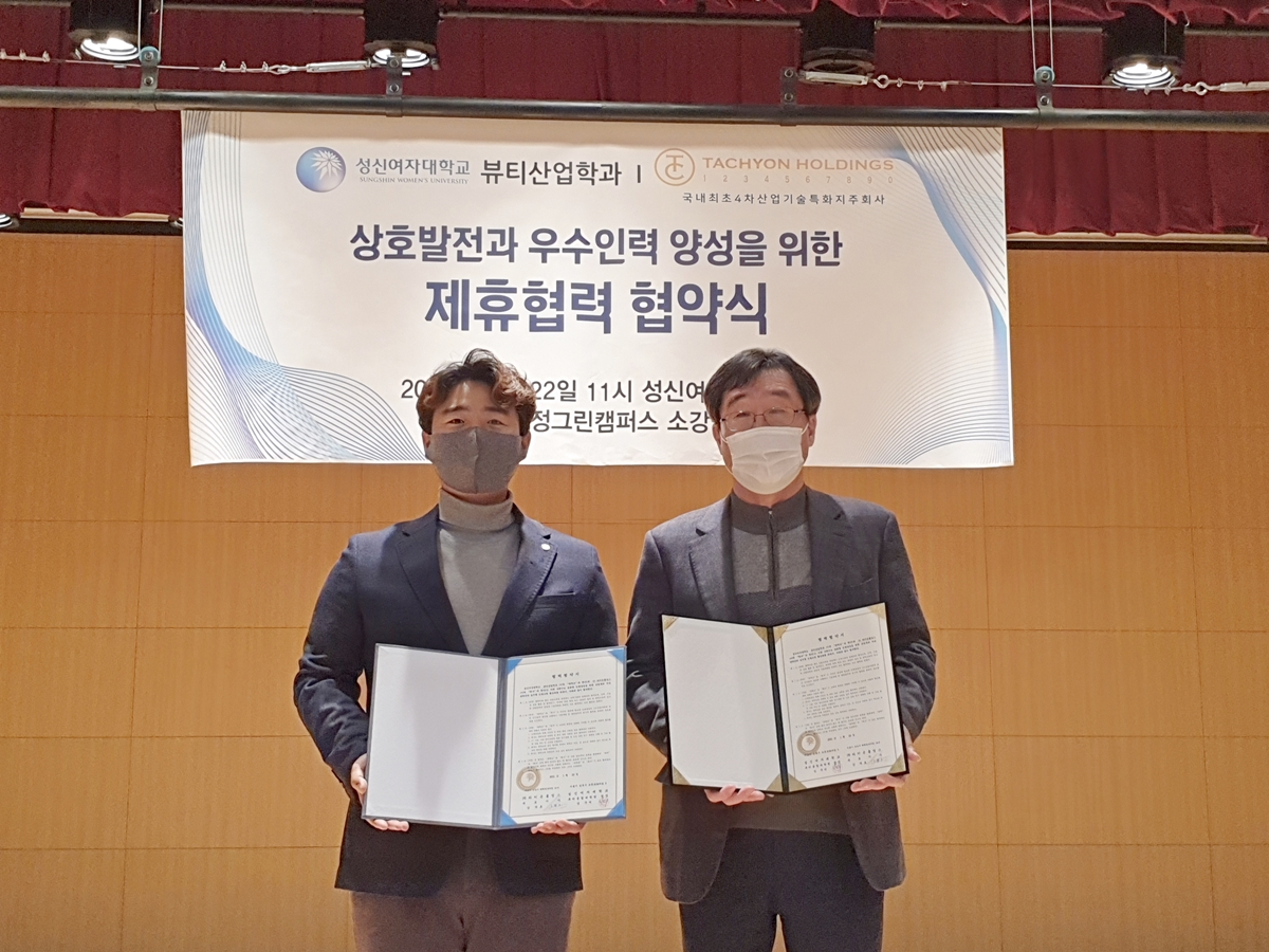 타키온홀딩스 강덕호 대표(왼쪽)와 성신여대 뷰티융합대학원 김주덕 원장이 양해각서를 들어보이고 있다. [타키온홀딩스 제공]