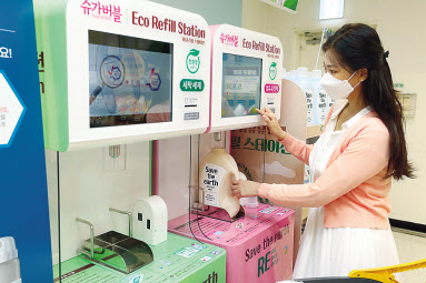 소비자가 이마트 매장 내에 설치된 리필용 세제 및 섬유유연제 자판기인 ‘에코 리필 스테이션’에서 세제를 리필하고 있다. [이마트 제공]
