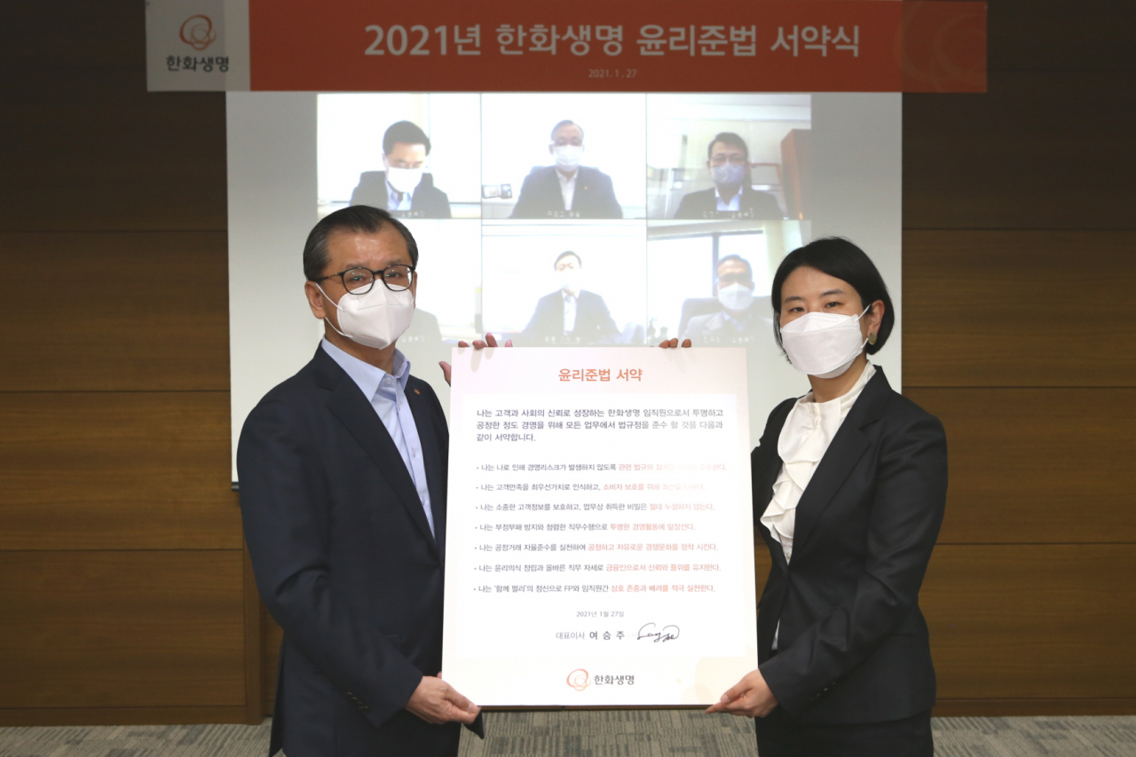 여승주 한화생명 대표와 여치경 준법감시인이 27일 오전 63빌딩에서 윤리준법 서약식에 참여해 기념촬영을 하고 있다. [한화생명 제공]