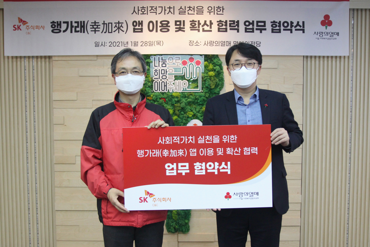 김성한 SK(주) C&C SV담당(오른쪽)과 김용희 서울 사랑의열매 사무처장이 '사회적 가치 실천을 위한 행가래(幸加來) 앱 이용 및 확산 협력' 협약 체결 후 기념 촬영을 하고 있다. [SK(주) C&C 제공]
