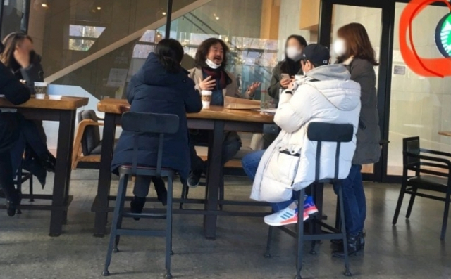 방송인 김어준(왼쪽 세 번째) 씨가 지난 19일 서울 마포구 상암동의 한 커피 전문점에서 마스크를 턱에 걸치고 일행 4명과 이야기하는 장면이 포착된 모습. [온라인 커뮤니티 캡처]