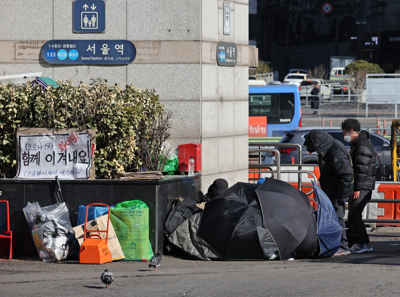 서울역광장 노숙인 관련 신종 코로나바이러스 감염증(코로나19) 누적 확진자가 39명을 기록한 29일 오후 서울역 광장에서 노숙인들이 이야기를 나누고 있다. [연합뉴스]