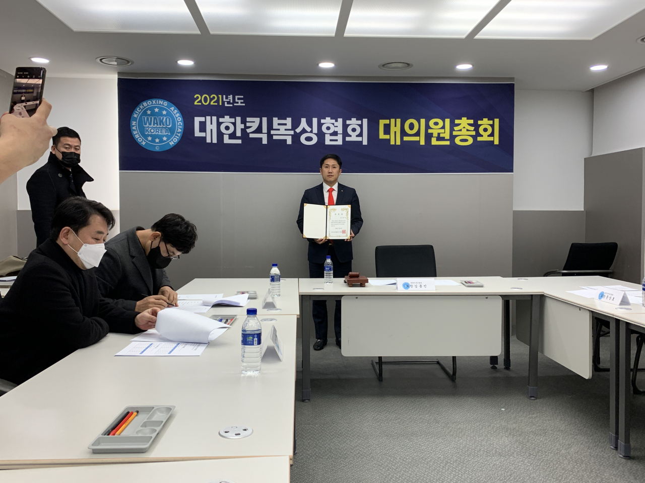 대한킥복싱협회 4대 회장 선거에 당선된 김종민 후보자가 대의원총회에서 당선증을 들어보이고 있다. [대한킥복싱협회 제공]