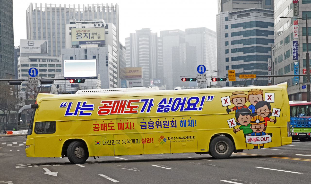 개인투자자 모임인 한국주식투자연합회(한투연)가 1일 오후 서울 세종로에서 공매도 반대 운동을 위해 '공매도 폐지', '금융위원회 해체' 등의 문구를 부착한 버스를 운행하고 있다. 연합뉴스