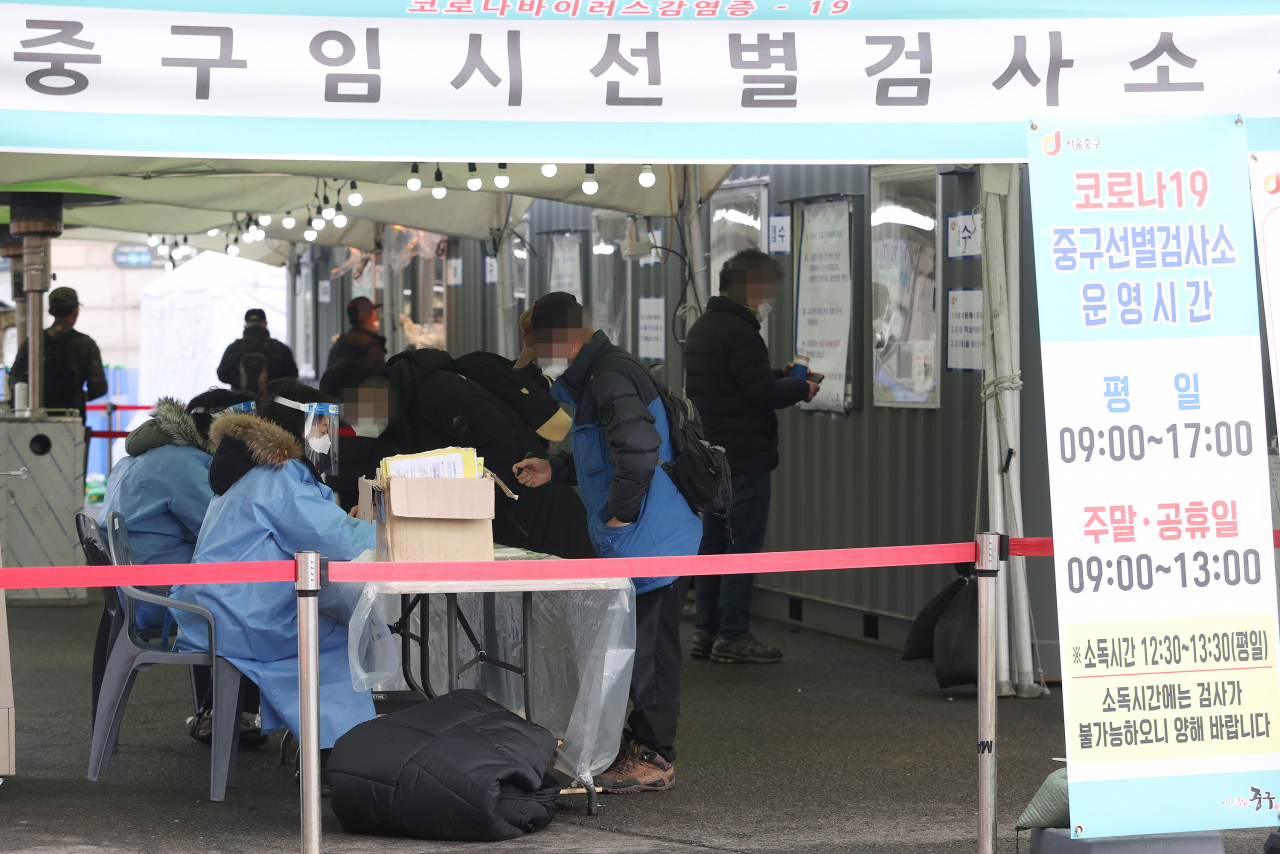1일 오전 서울역광장에 설치된 임시선별진료소에서 시민들이 코로나19 검사를 받기 위해 서류를 작성하고 있다. [연합]