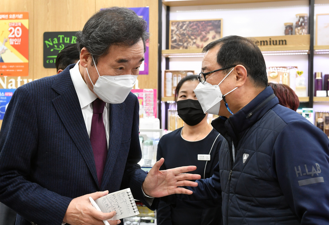 [사진=이낙연 더불어민주당 대표가 코로나19 이익공유제 실현 현장 방문의 일환으로 서울 영등포 지하상가를 찾아 가맹점주의 얘기를 듣고 있다.][연합]