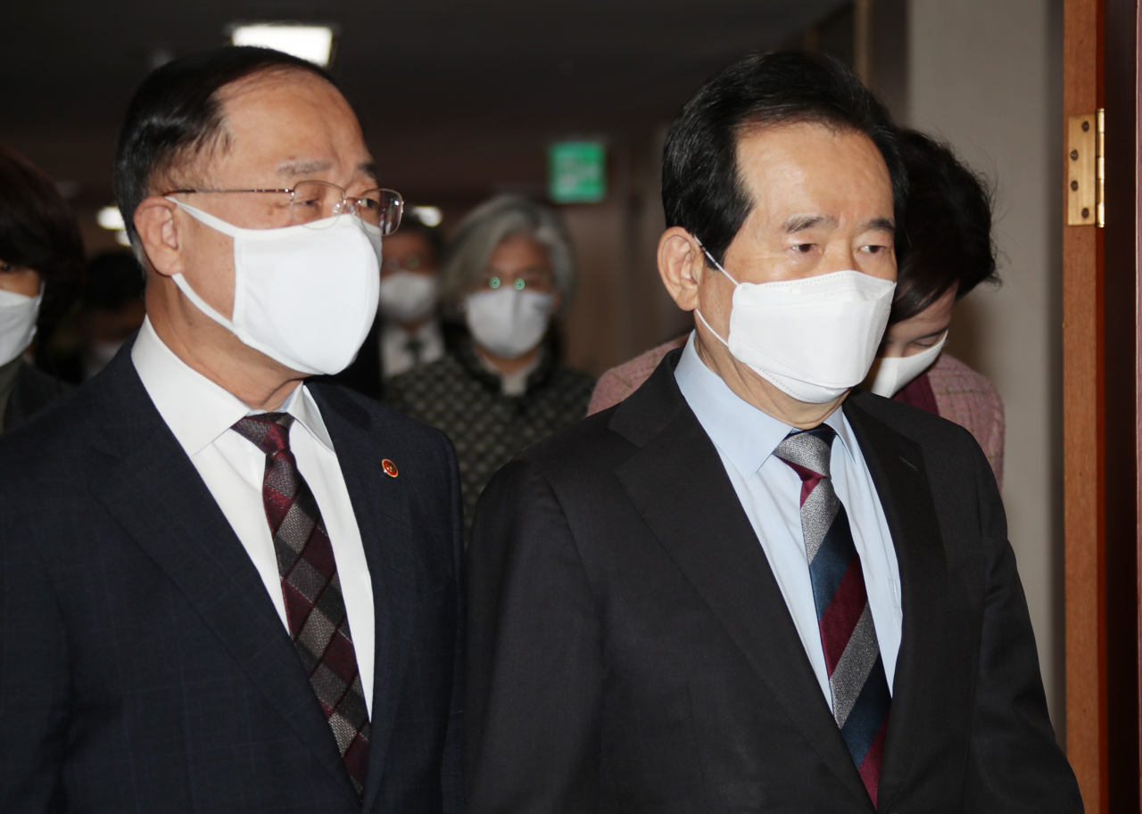 정세균 국무총리가 2일 정부서울청사에서 열린 국무회의에 홍남기 부총리 겸 기획재정부 장관과 함께 참석하고 있다. 홍 부총리는 이날 페이스북을 통해 “추가적 재난지원금 지원이 불가피하다고 하더라도 전국민 보편지원과 선별지원을 한꺼번에 모두 하겠다는 것은 정부로서는 받아들이기 어렵다”며 “기재부를 향한 어떠한 부당한 비판도 최일선에서 장관이 막을 것”이라고 강조했다. [연합]