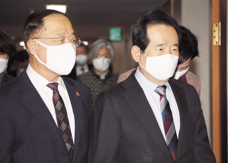 정세균 국무총리가 2일 정부서울청사에서 열린 국무회의에 홍남기 부총리 겸 기획재정부 장관과 함께 참석하고 있다. 홍 부총리는 이날 페이스북을 통해 “추가적 재난지원금 지원이 불가피하다고 하더라도 전국민 보편지원과 선별지원을 한꺼번에 모두 하겠다는 것은 정부로서는 받아들이기 어렵다”며 “기재부를 향한 어떠한 부당한 비판도 최일선에서 장관이 막을 것”이라고 강조했다. [연합]