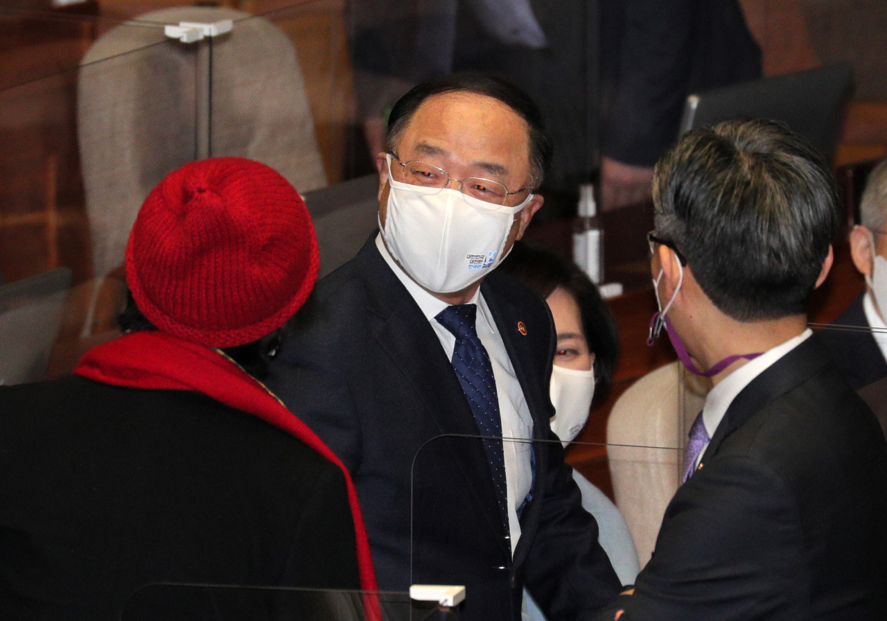 홍남기 경제부총리(가운데)가 3일 국회 본회의장에서 열린민주당 김진애 의원(왼쪽)과 대화하고 있다. 홍 부총리는 이날 본회의가 끝나고 기자들과 만나 “(이낙연 더불어민주당 대표가) 재난지원금과 추가경정예산 관련해 발언을 했는데 혹시 정부와 다른 이견사항이 국민에게 확정된 것으로 전달이 될까봐 재정당국 입장을 절제된 표현으로 말한 것”이라고 밝혔다. [연합]