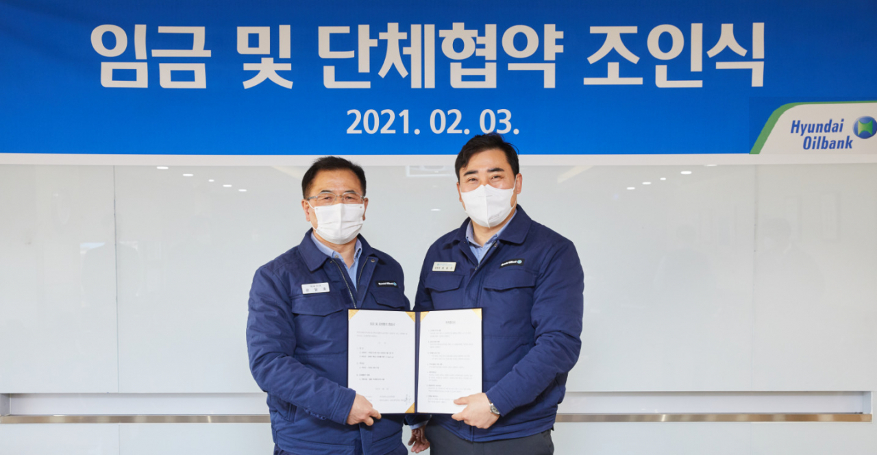 강달호 현대오일뱅크 사장(왼쪽)과, 최용수 노조위원장이 3일 충남 서산시 현대오일뱅크 대산공장에서 올해 임금 인상률을 동종사 평균으로 하는 내용의 합의서에 공동 서명했다. [현대오일뱅크 제공]