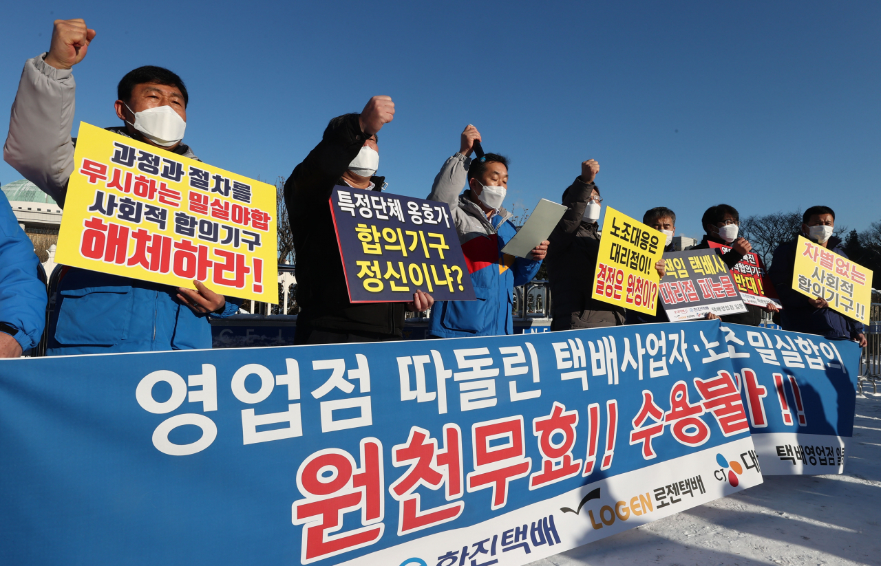 국내 4개 택배사 대리점 관계자들이 4일 오전 서울 영등포구 국회 앞에서 기자회견을 열고 구호를 외치고 있다. 이날 이들은 대리점과 택배 종사자들의 의견이 무시된 합의에 대한 재검토 등을 촉구했다. [연합]