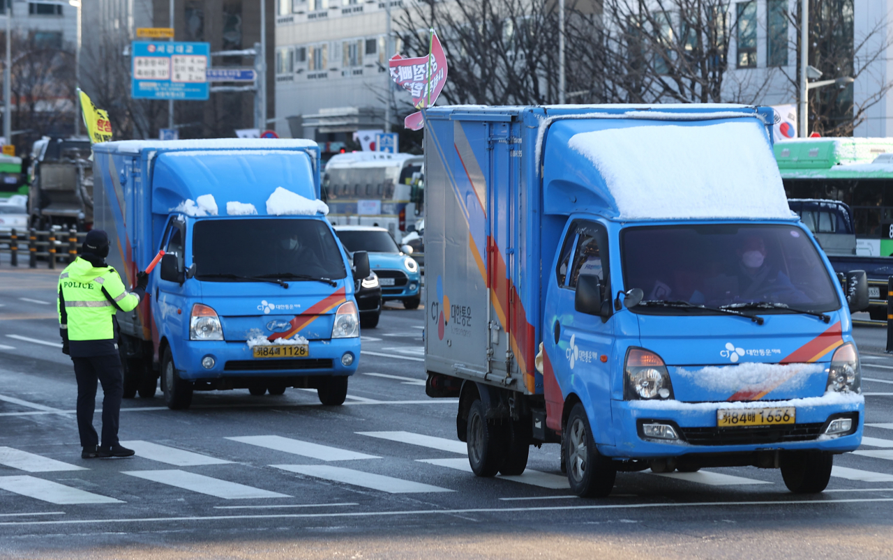 사회적 합의 수용불가 입장을 밝힌 국내 4개 택배사 대리점의 차량들이 4일 오전 국회 앞에서 깃발을 달고 이동하고 있다. [연합]