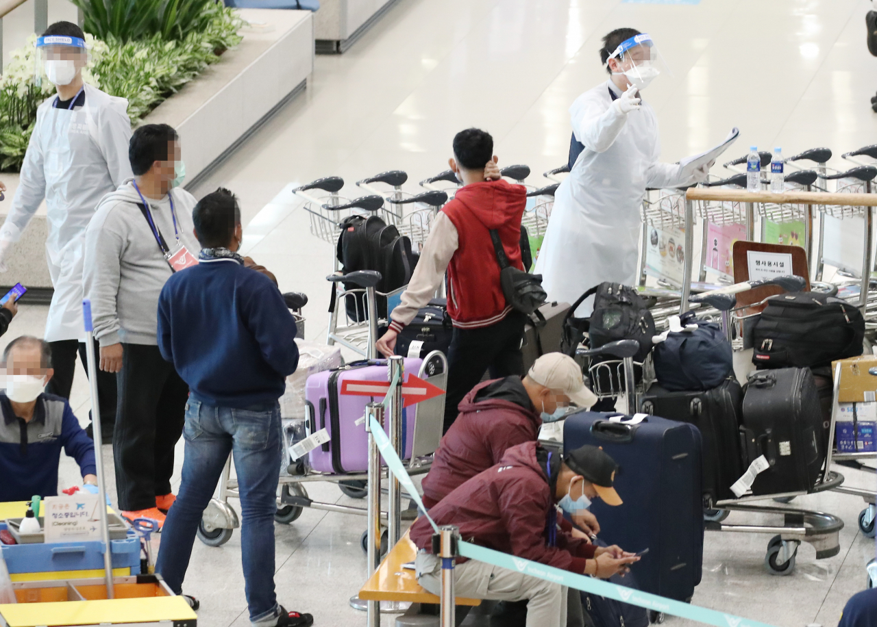영국발 변이 바이러스의 첫 지역사회 집단감염 사례가 발생한 가운데 4일 오전 인천국제공항 제1터미널에서 방역관계자가 해외입국자들에게 안내의 말을 전하고 있다. 한편 중앙방역대책본부에 따르면 이날 0시 기준 국내 코로나19 신규 확진자 수는 451명으로 이중 지역발생이 429명, 해외유입이 22명으로 나타났다. 연합뉴스