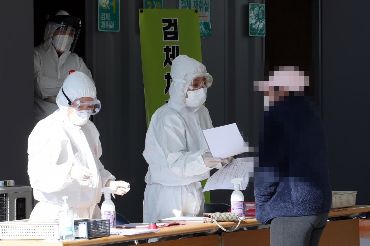 4일 오전 전남 나주시 보건소 주차장에 마련된 신종 코로나바이러스 감염증(코로나19) 선별진료소에서 외국인 주민이 진단검사 절차를 안내받고 있다. [연합]