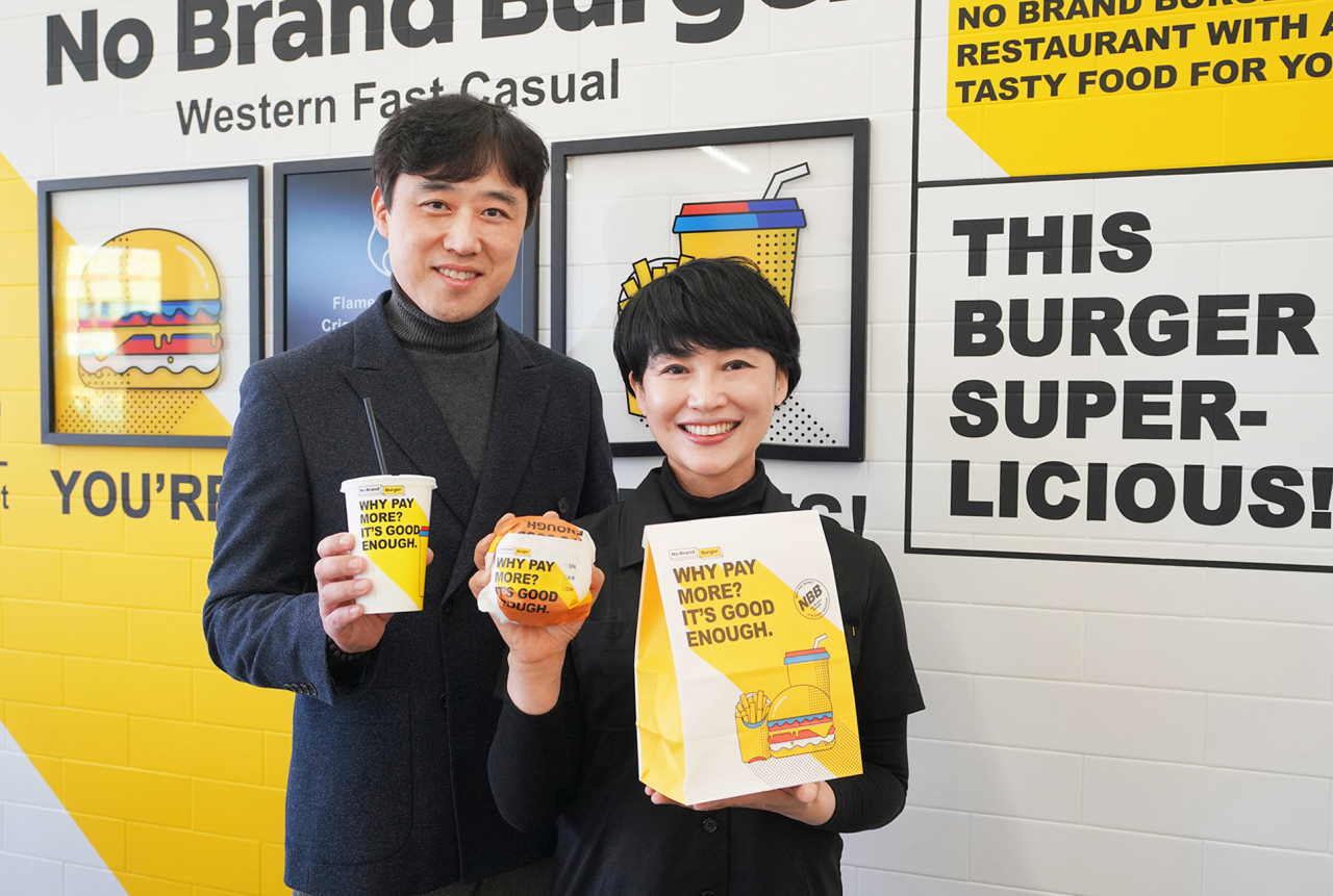 여미정(오른쪽) 경기도 파주 금촌로터리점 가맹점주와 이승우 신세계푸드 노브랜드 버거 FC개발팀장이 시그니처 제품을 들고 기념촬영을 하고 있다. [신세계푸드 제공]