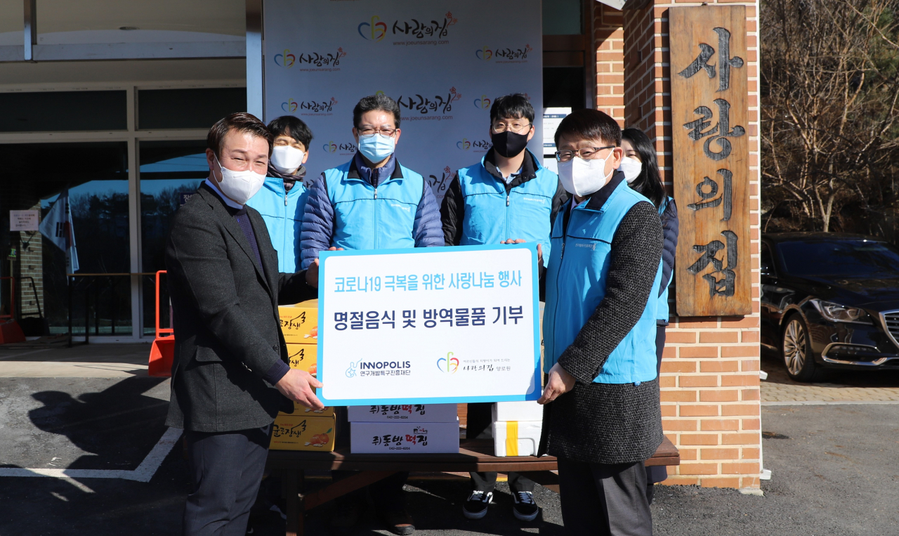 양성광(오른쪽) 특구진흥재단 이사장이 코로나19 극복을 위한 명절음식 및 방역물품을 전달하고 있다.[연구개발특구진흥재단 제공]