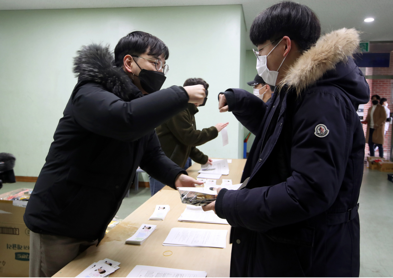 2021학년도 대학수학능력시험을 하루 앞둔 지난해 12월2일 오전 광주 북구 광주일고에서 교사들이 3학년 수험생들에게 수험표를 나눠주며 격려하고 있다. [연합]