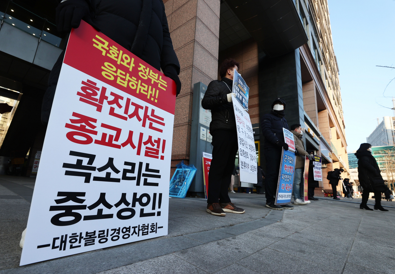 지난 2일 오전 서울 중구 LW컨벤션에서 '사회적 거리두기 단계 개편을 위한 공개토론회'가 열렸다. 토론회장 앞에서 1인 시위에 나선 자영업자들이 방역지침 끝장토론, 영업시간 연장 등을 촉구하고 있다. [연합]