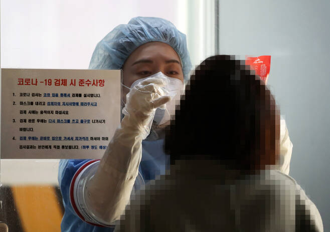 한 의료진이 선별진료소를 찾은 시민의 검체를 채취하고 있다.사진은 기사와 직접 관계 없음[연합]