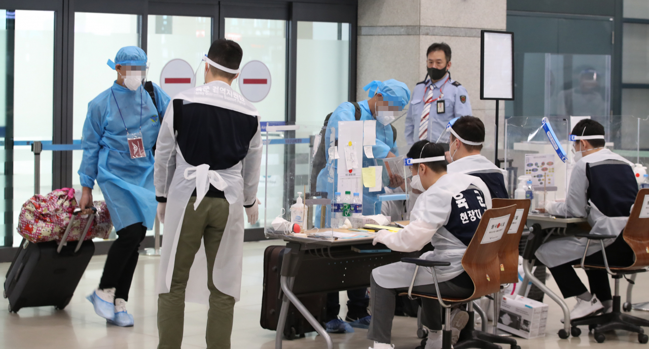 영국발 신종 코로나바이러스 감염증(코로나19) 변이 바이러스로 4차 유행에 대한 우려가 커지는 가운데 5일 영종도 인천국제공항에서 방역복을 입은 해외 입국자들이 육군 검역지원단으로부터 안내를 받고 있다. 연합뉴스