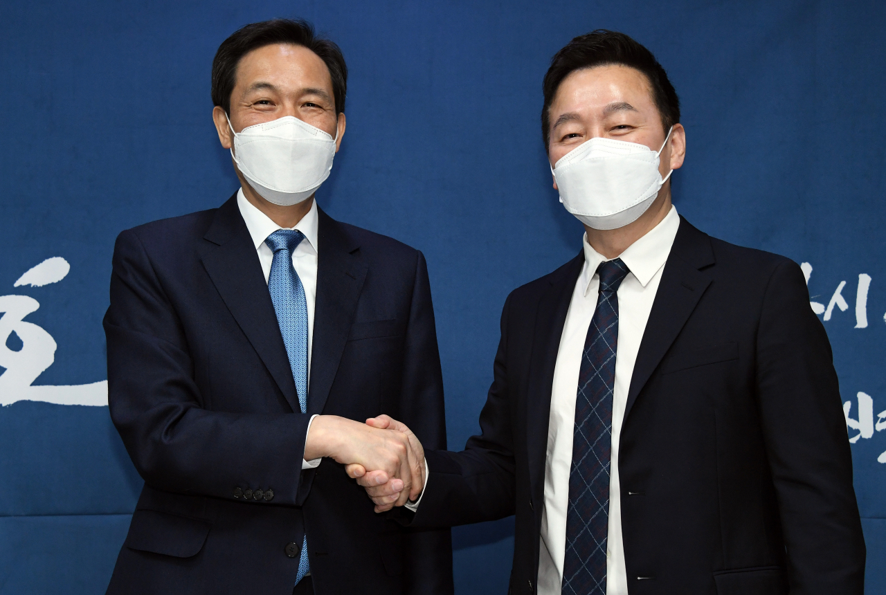 더불어민주당 우상호 서울시장 보궐선거 예비후보(왼쪽)와 열린민주당 정봉주 서울시장 보궐선거 예비후보가 지난 7일 오전 국회 의원회관에서 만나 범여권 서울시장 후보 단일화 합의를 발표하고 악수하고 있다. [연합]