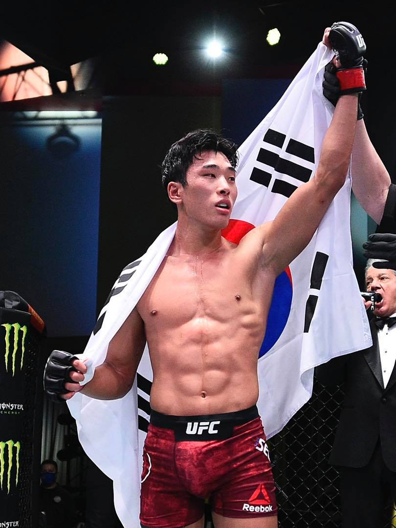2연승을 거둔 최승우가 케이지 안에서 등에 태극기를 두른 채 세리머니 하고 있다. [UFC 제공]