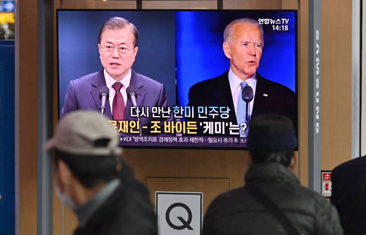South Korean citizens watch a TV report on the inauguration of US President Joe Biden at Seoul Station in central Seoul last month. (AFP-Yonhap)