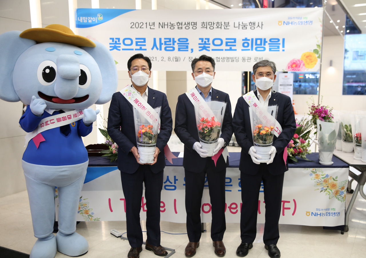 NH농협생명 김인태 대표이사(오른쪽 두 번째), 경영기획부문 전용범 부사장(오른쪽 첫 번째), 경영지원부 주경돈 부장(오른쪽 세 번째)이 화훼농가 지원 나눔행사를 기념하여 사진을 촬영하고 있다.