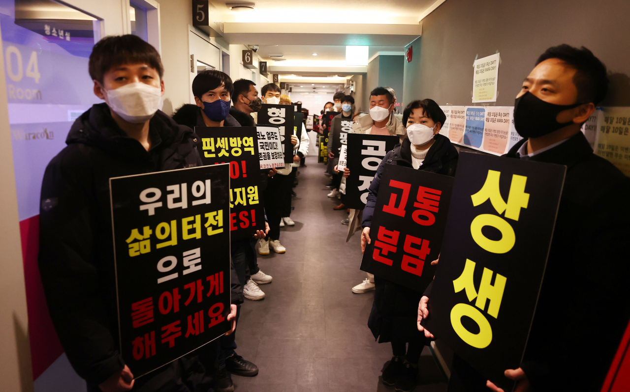 9일 자정 서울 서대문구의 한 코인노래방에서 코로나19 대응 전국자영업자 비상대책위 주최로 열린 방역기준 불복 개점 시위에서 참석자들이 정상 영업을 촉구하며 구호를 외치고 있다. 이날 시위에서 코인노래방 업주들은 방역 당국의 획일적인 영업시간 제한 폐지, 형평성 있는 방역기준 조정과 대책 마련을 촉구했다. [연합]