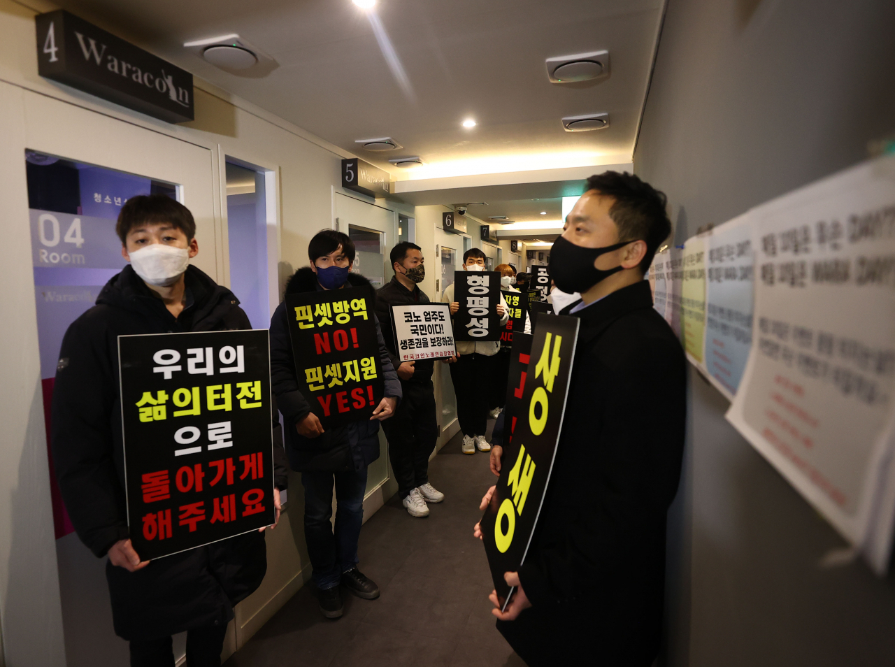9일 자정 서울 서대문구의 한 코인노래방에서 코로나19 대응 전국자영업자 비상대책위 주최로 열린 방역기준 불복 개점 시위에서 참석자들이 정상 영업을 촉구하며 구호를 외치고 있다. 이날 시위에서 코인노래방 업주들은 방역 당국의 획일적인 영업시간 제한 폐지, 형평성 있는 방역 기준 조정과 대책 마련을 촉구했다. [연합]
