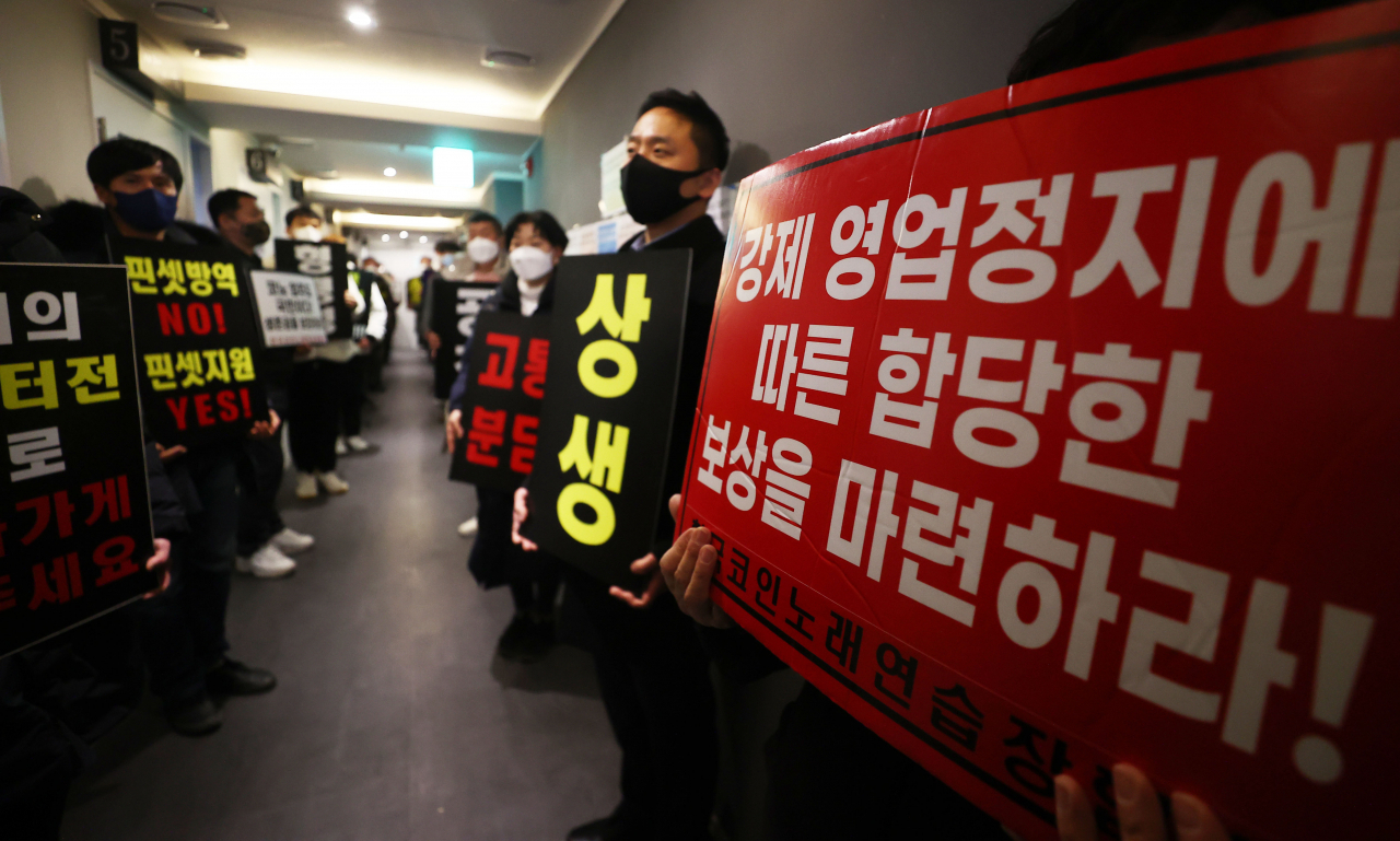 9일 자정 서울 서대문구의 한 코인노래방에서 코로나19 대응 전국자영업자 비상대책위 주최로 열린 방역기준 불복 개점 시위에서 참석자들이 정상 영업을 촉구하며 구호를 외치고 있다. 이날 시위에서 코인노래방 업주들은 방역 당국의 획일적인 영업시간 제한 폐지, 형평성 있는 방역기준 조정과 대책 마련을 촉구했다. [연합]