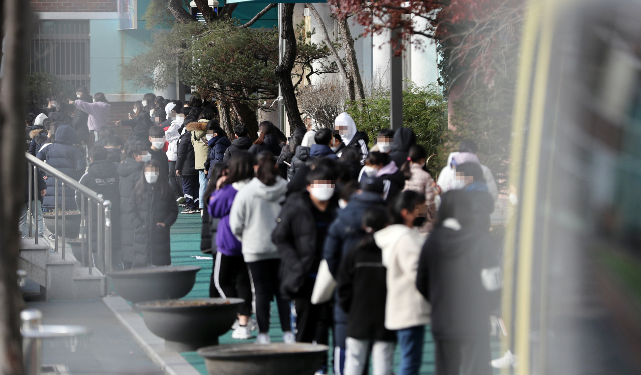코로나19 확진자가 발생한 것으로 알려진 서울 중랑구 한 초등학교 학생들이 지난해 12월2일 체육관에 차려진 임시 선별진료소에서 검사를 받기 위해 줄 서 대기하고 있는 모습. [연합]