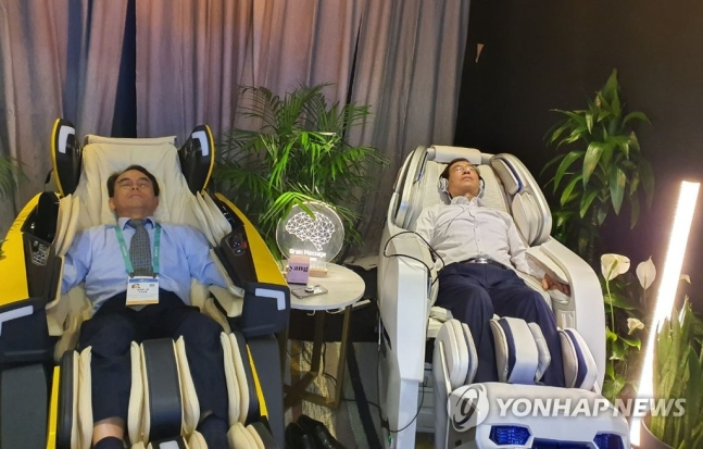 지난해 1월 미국 CES 출장 길에 함께 올랐던 박원순 전 시장과 진대제 전 장관이 나란히 안마의자에 누워 제품을 체험하고 있다. [연합뉴스]