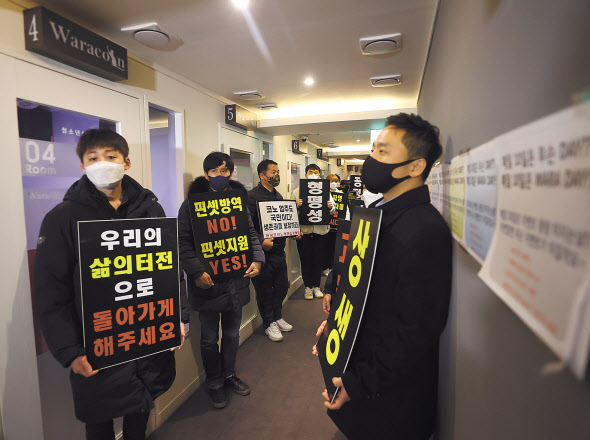 9일 자정 서울 서대문구의 한 코인노래방에서 코로나19 대응 전국자영업자 비상대책위 주최로 열린 방역기준 불복 개점 시위에서 참석자들이 정상 영업을 촉구하며 구호를 외치고 있다. 연합]