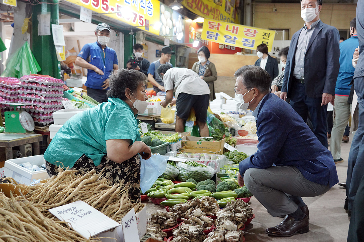 President Moon Jae-in talks with a merchant at a traditional market in central Seoul during last year's Chuseok holiday. (Cheong Wa Dae)