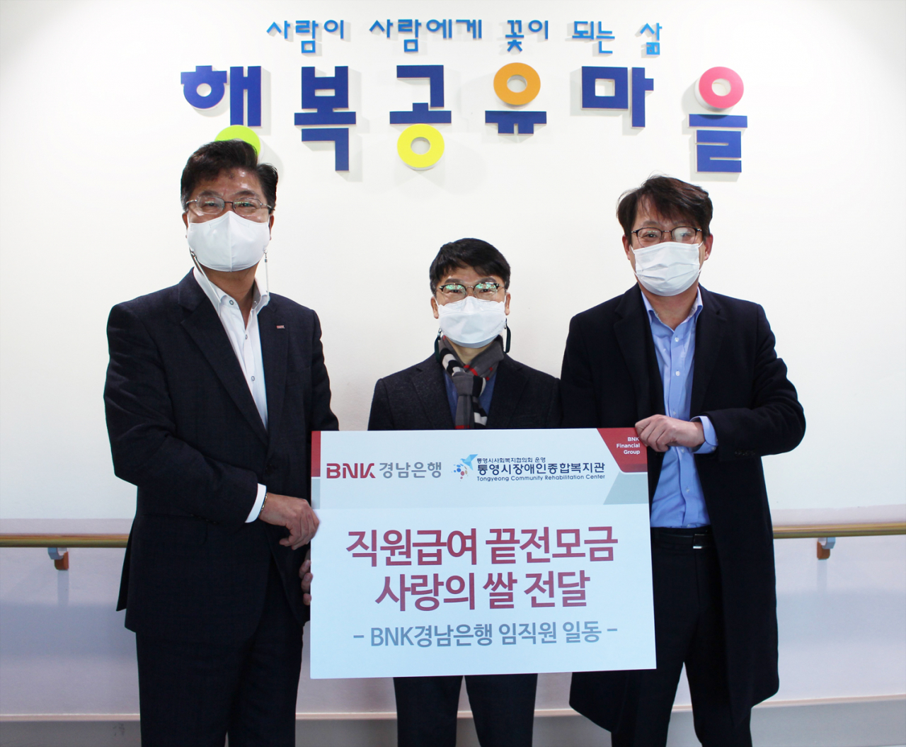 BNK경남은행 김종학 팀장(사진 오른쪽 첫번째)과 통영지점 손영익 영업점장이 통영시장애인종합복지관 정병두 관장(사진 오른쪽 두번째)에게 ‘백합나눔회성금 기탁 증서’를 전달하고 있다.[경남은행 제공]