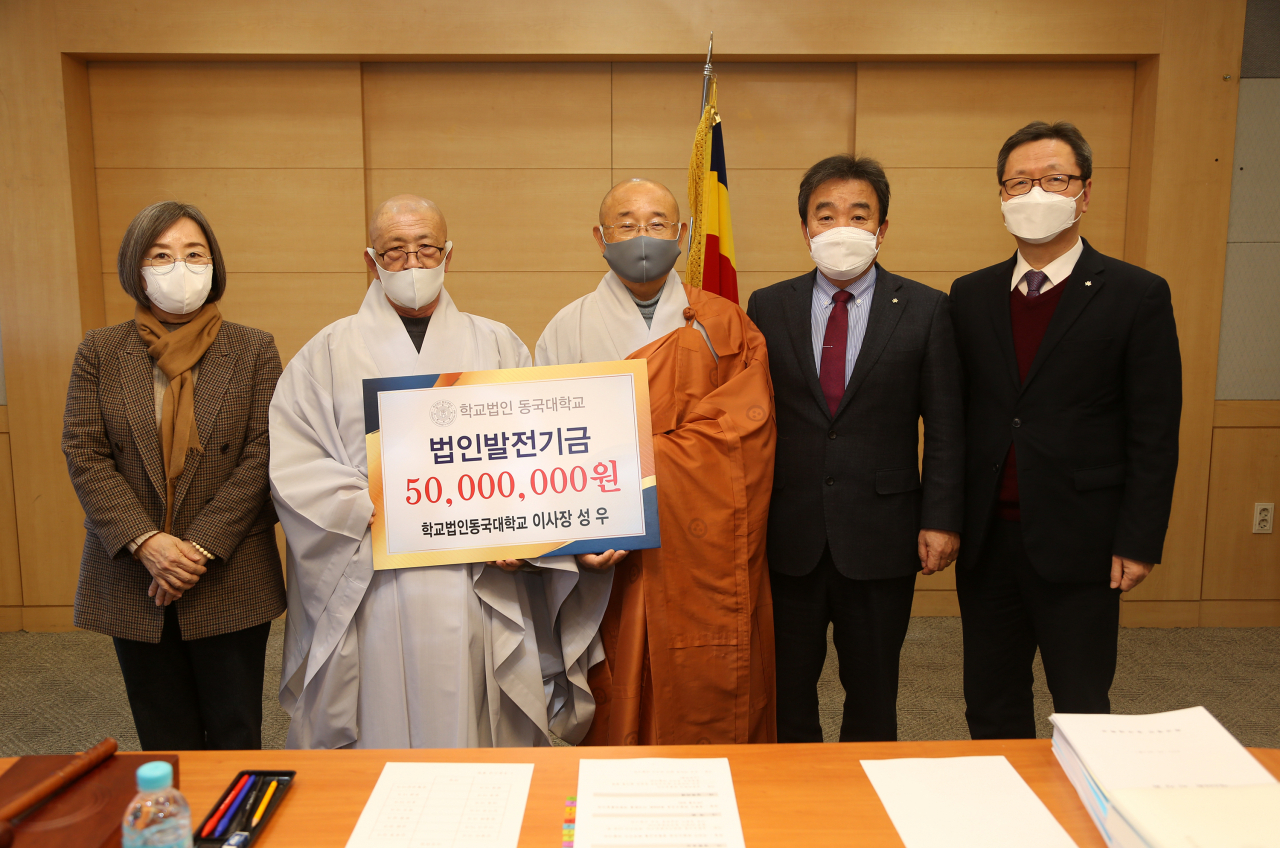 학교법인 동국대학교 이사장인 성우 스님(가운데)이 9일 학교 발전기금 5000만원을 기부하고 기념사진을 촬영하고 있다. 사진 왼쪽부터 이영경 동국대 경주캠퍼스 총장, 성월 스님(동국대 상임이사), 성우 스님, 윤성이 동국대 총장, 조성민 동국대 의료원장. [동국대 제공]