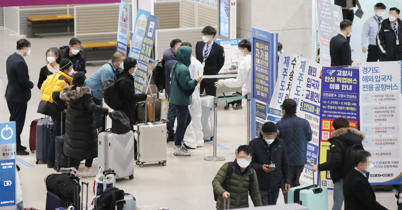 설 연휴를 이틀 앞둔 9일 오전 인천국제공항 제1터미널 입국장에서 해외입국자들이 방역관계자의 설명을 듣고 있다. 연합뉴스