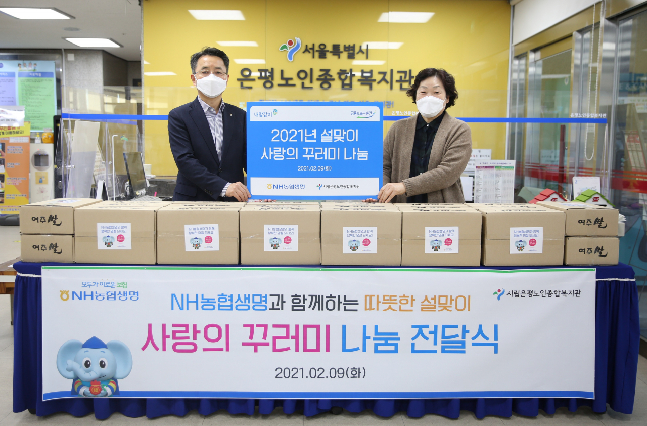 NH농협생명 김인태(왼쪽) 대표이사와 은평농인종합복지관 김승자 관장이 사랑의 꾸러미 나눔 전달식에서 사진촬영을 하고 있다